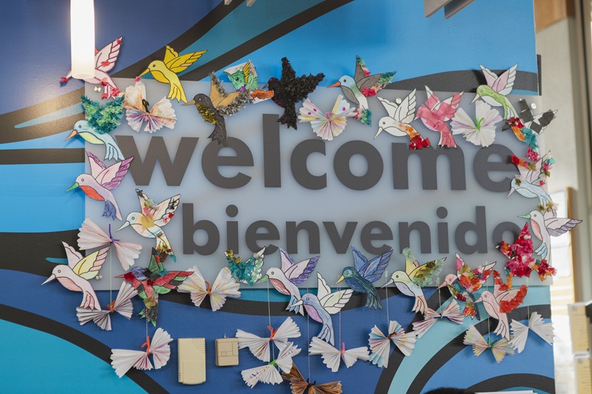 A sign that says welcome and benevidos at the South Park Branch, bordered by colorful origami creations.